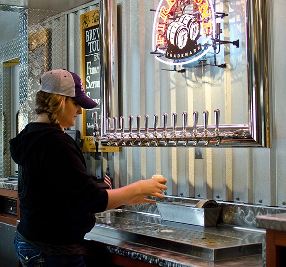 A server pours beer at Firestone Walker Brewing Co.’s Paso Robles campus, where the firm is building out more production space to gear up for more bottling. (Alex Drysdale / Business Times photo)