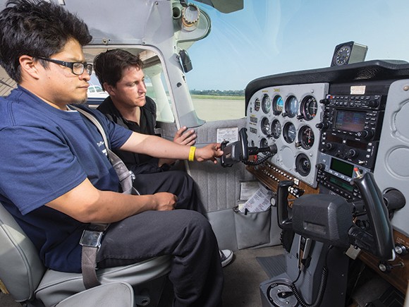 Flight instructor Bill Peterson performs a preflight inspection with student Luis Santos as part of the programs held by A Different Point of View, a nonprofit flight school for underprivileged students. The nonprofit will compete in Fast Pitch SB next month. (Nik Blaskovich / Business Times photo)