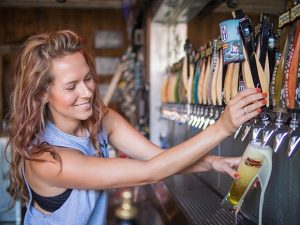 Terra Lee Inglis, bar manager at Figueroa Mountain Brewing Co., pours a draft beer for a customer. (Nik Blaskovich / Business Times photo)