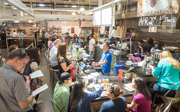 Jerry Lee, owner of Empty Bowl Gourmet Noodle Bar, runs the cash register as customers shop at the Santa Barbara Public Market. (Nik Blaskovich / Business Times photo)