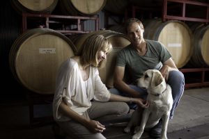 Terry and Jennifer Hoage in their winery’s barrel room with their 2-year-old Labrador, Lexi.